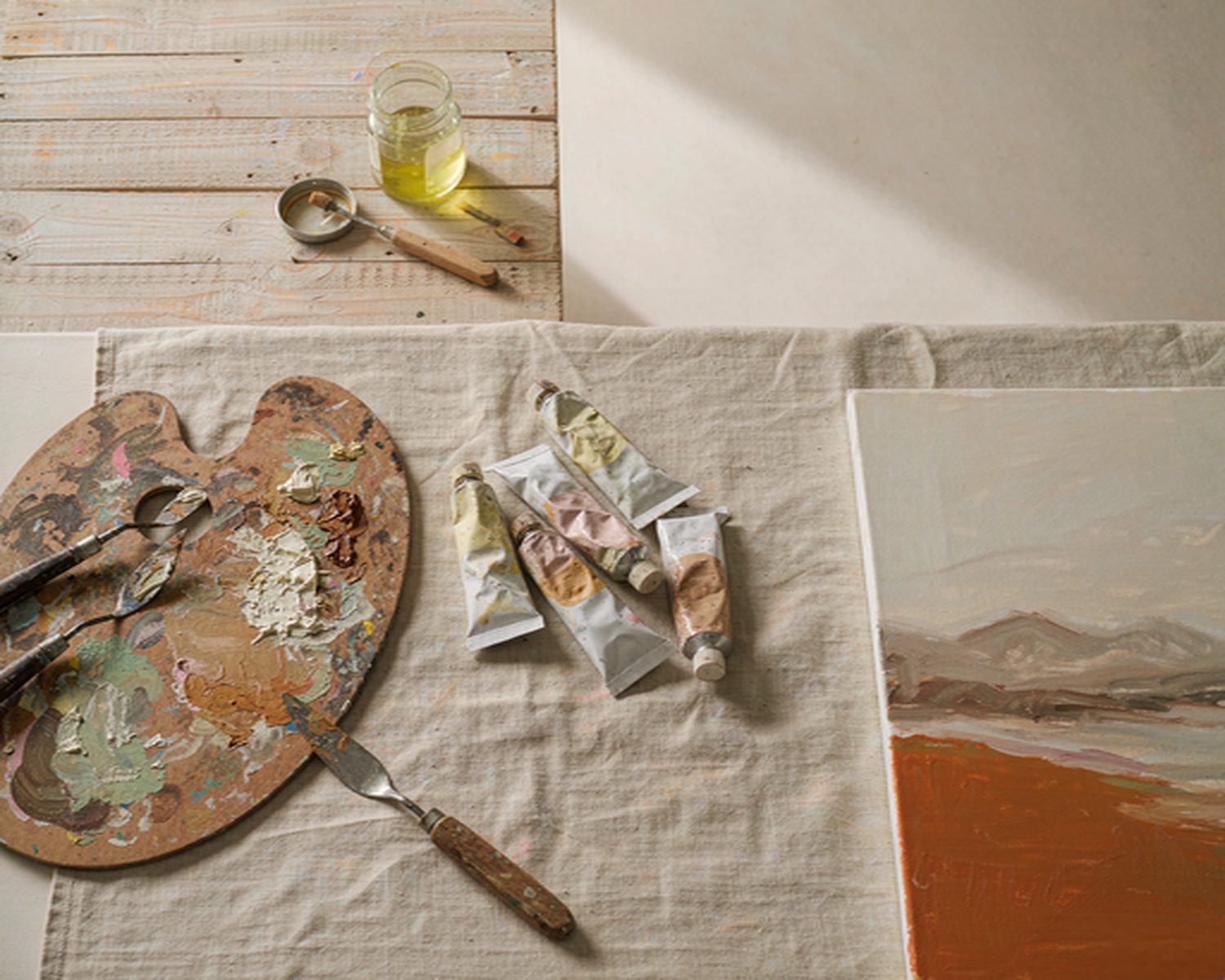 Oil paints and palette knives on an artist's worktable
